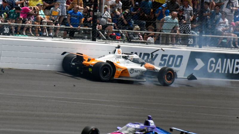 Felix Rosenqvist, top, of Sweden, hits the wall in the second turn during the Indianapolis 500...