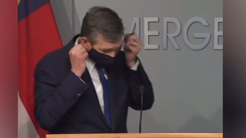 NC Gov. Roy Cooper removes his face mask before a press conference on June 25, 2020.