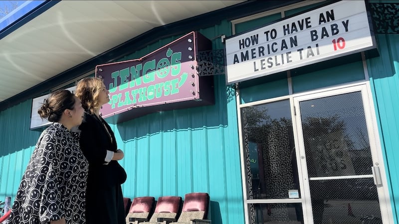 Film makers admire marquee with their movie title on display.