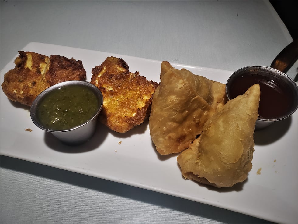 Vegetable Samosa, a crispy, fried pie stuffed with potatoes, peas and spices...accompanied by...