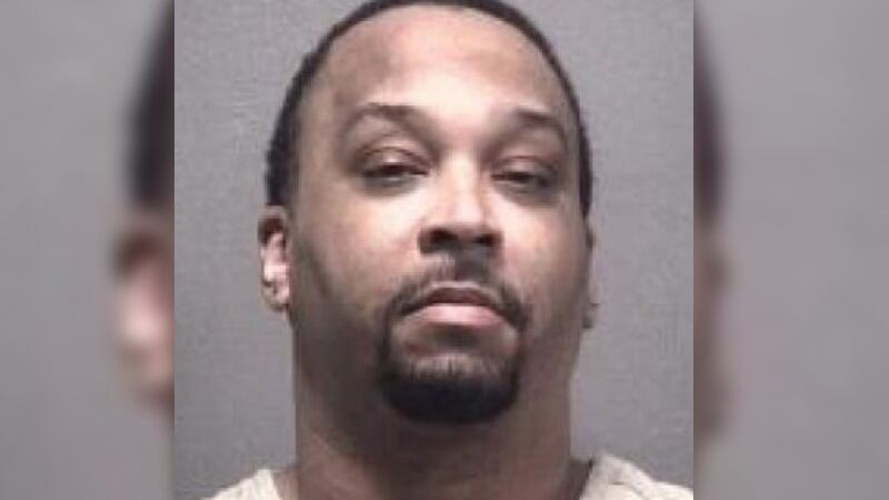 A mugshot of a man with extremely short hair and a goatee.
