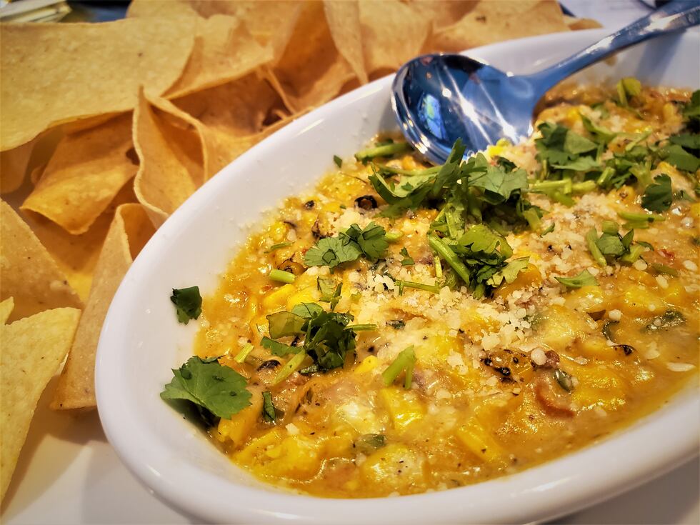 A bowl of melted cheese, roasted corn, peppers, and spices makes for the perfect summer...