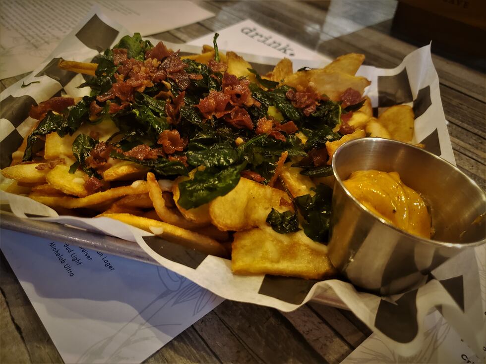 Thin sliced steak fries are the foundation of this culinary creation boasting fried spinach...