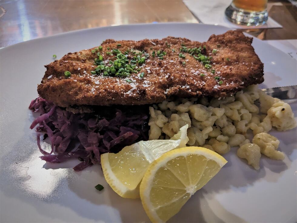 A perfectly fried pork cutlet rests on a bed of braised cabbage and spatzle, though I highly...