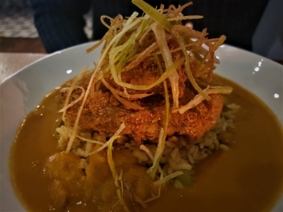 Perfectly fried fish with crispy leeks on top of a tasso ham dirty rice and a sweet potato...