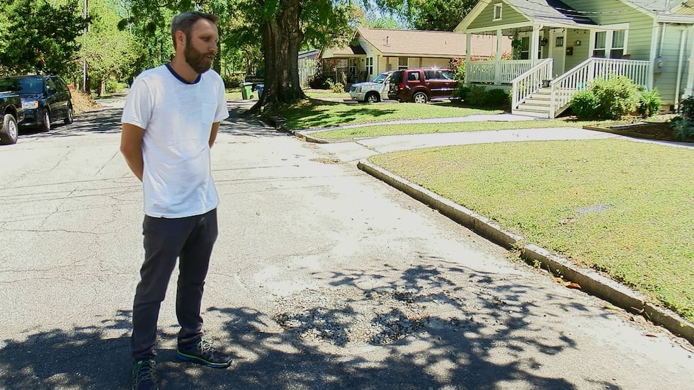 Wilmington Resident Matt Krise stands next to the area where a "lake" forms in front of his...