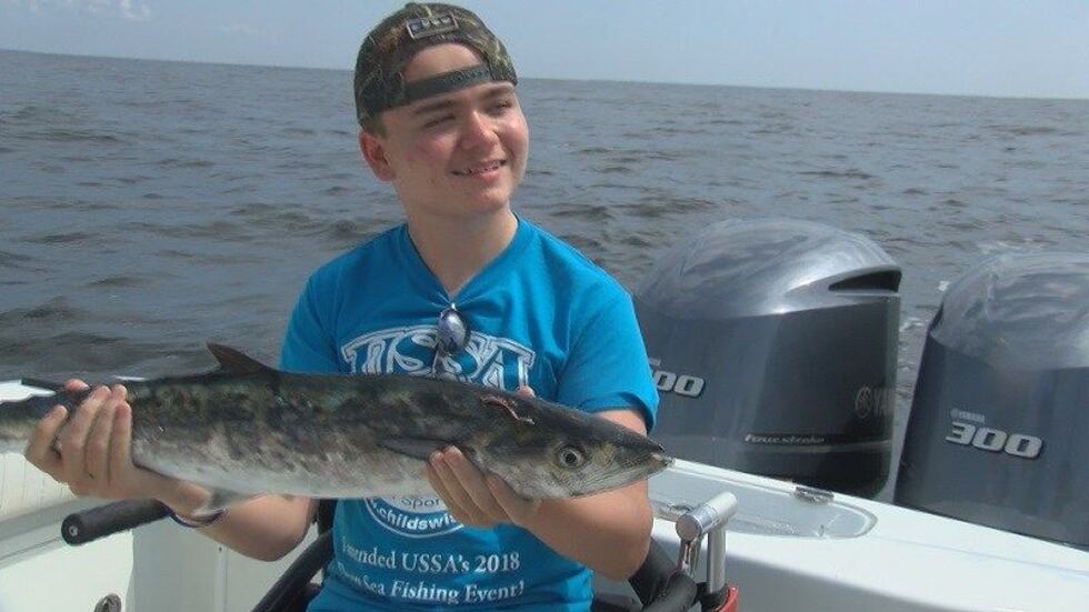 Robby Reavis holds his King Mackerel he caught at a fishing event (Source: WECT)