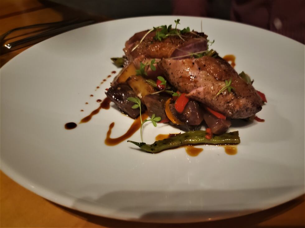 A beautiful piece of duck, on a bed of various vegetables and plated beautifully so a...